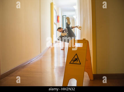 Man slips on wet floor Stock Photo