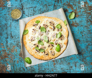 Homemade mushroom pizza with basil over blue wooden background Stock Photo