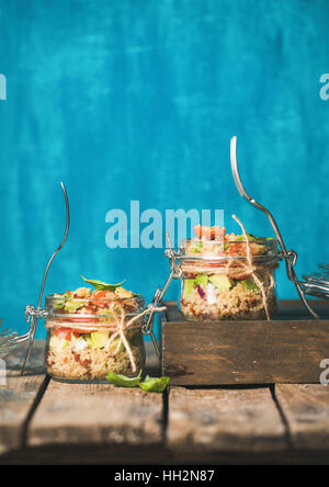 Homemade jar quinoa salad with cherry-tomatoes, avocado and fresh basil Stock Photo