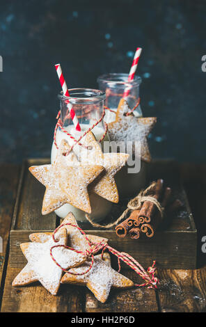 Bottles with milk and Christmas homemade gingerbread star shaped cookies Stock Photo