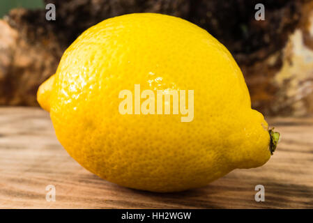 Sharp and sour lemon on wooden cutting board. Stock Photo