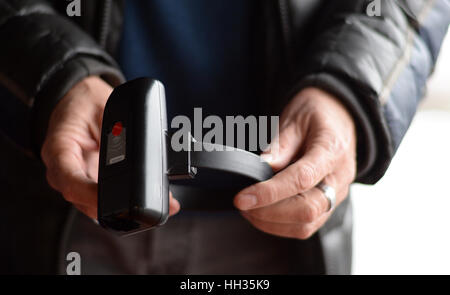 Bad Vilbel, Germany. 11th Jan, 2017. Hans-Dieter Amthor of the IT department of the Hessian department of justice holds up an electronic ankle monitor in Bad Vilbel, Germany, 11 January 2017. The offenders are controlled from the joined electronical control center of the states (GUL) in Bad Vilbel. Photo: Susann Prautsch/dpa/Alamy Live News Stock Photo