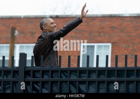 Washington, USA. 16th January, 2017.US President Barack Obama stands on a picnic table to wave over a fence to local people cheering for him, after attending a service event for Martin Luther King Jr. Day at the Jobs Have Priority Naylor Road Family Shelter. Credit: Michael Reynolds/Pool via CNP /MediaPunch/Alamy Live News Stock Photo