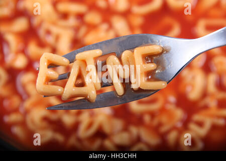 Spaghetti letter spelling the word 'Eat Me' with the letters held up on a fork.