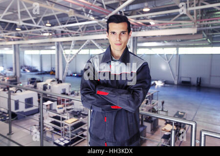 Portrait of worker with crossed arms, steel factory background Stock Photo