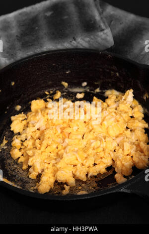 Scrambled egg in a cast iron frying pan with toast.  Edited using selective color Stock Photo