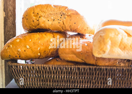 fresh bread buns in a basket on a wooden table Stock Photo