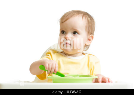 Baby girl eating yogurt or puree isolated on white Stock Photo