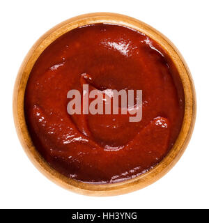 Tomato ketchup in wooden bowl. Also called catsup or ketsup, is a red table sauce made from tomatoes, often used as a condiment. Stock Photo