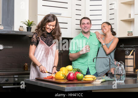 Three friends having fun in the kitchen Stock Photo