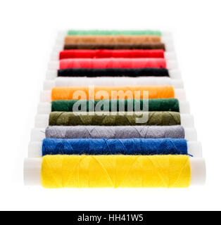 Different color Sewing Threads on a roll. Isolated on white background. Sewing accessories for hobby of professional fashion use. Stock Photo