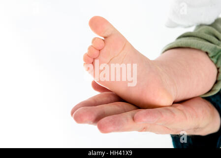 Baby Foot in parents hand. Parenthood, family, twins, children and love concept. Stock Photo