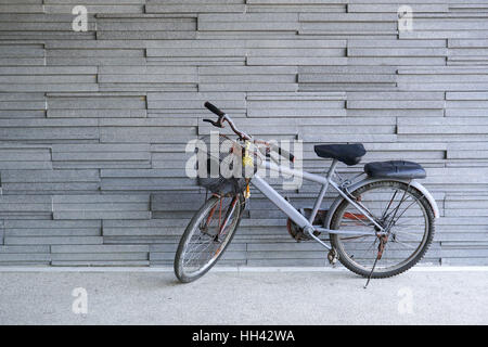 bicycle leaning against stone wall Stock Photo