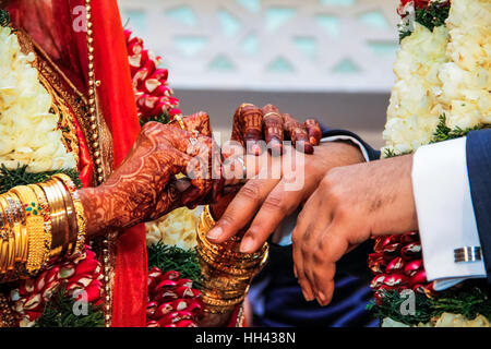 Bride putting wedding ring on groom's finger at traditional south Indian wedding ceremony Stock Photo