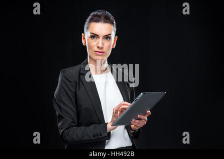 Young professional businesswoman in suit using digital tablet Stock Photo