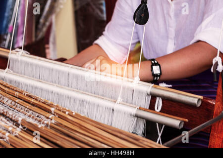 Woman weaving silk in Thailand. Stock Photo