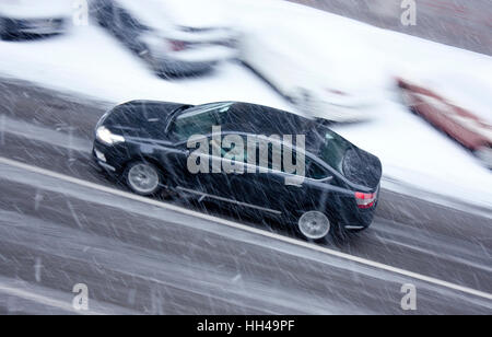 Snowy day in the city: A driving car in the street hit by the heavy snow, in motion blur Stock Photo