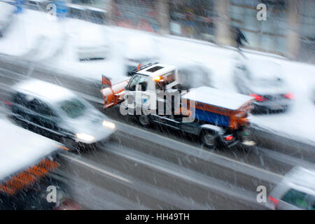 Belgrade, Serbia - January 9, 2017 : Snowplow among other vehicles in motion on the  street of snowy Belgrade on minus 10 Celsius, panning shot Stock Photo