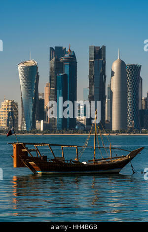 Dhow traditional sailing vessel with the financial area skyline behind, Doha, Qatar Stock Photo