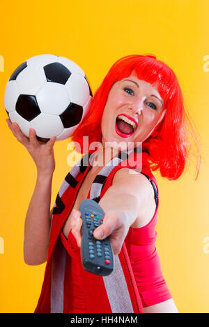 Flippy woman with football and remote control Stock Photo