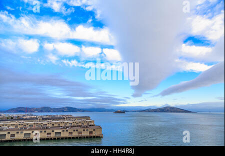 Alcatraz Prison Beyond San Francisco Piers Under Nice Clouds Stock Photo