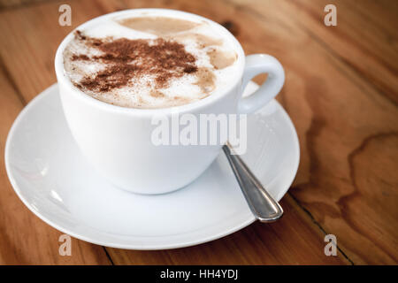 Coffee with milk or cappuccino with cinnamon in a plastic cup take