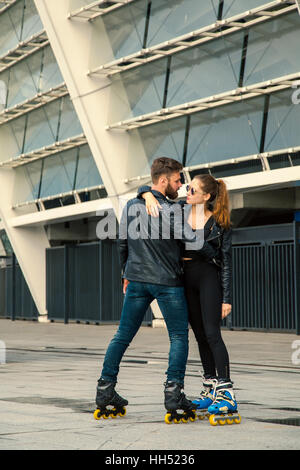 Beautiful roller skater couple with hipster style skating after the rain. Stock Photo