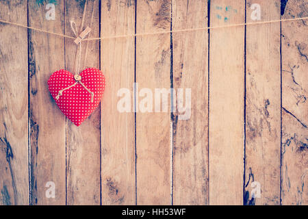 Heart fabric hanging on clothesline and wood background with space. Stock Photo