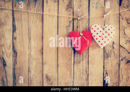 Two heart fabric hanging on clothesline and wood background with space. Stock Photo