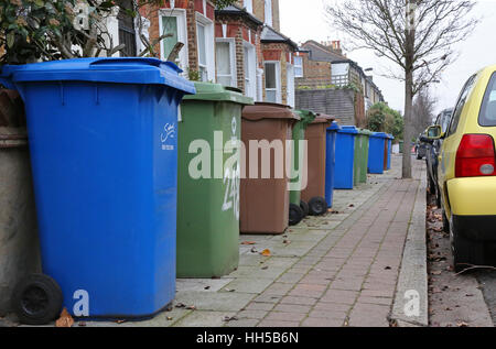 Plastic 'wheelie bins' crowd the pavement in a south London residential street, Peckham. UK Stock Photo