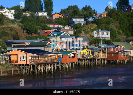 CASTRO, CHILE - FEBRUARY 6, 2016: Colorful Palafitos, traditional wooden stilt houses at low tide along the Rio la Chacra River Stock Photo