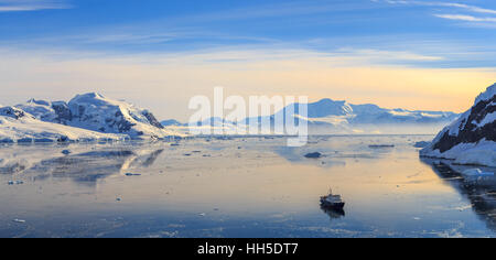 Neco bay surrounded by glaciers and cruise vessel drifting slowly, Antarctic Stock Photo