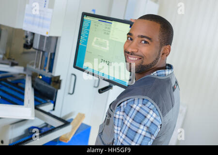 worker posing next to a screen Stock Photo
