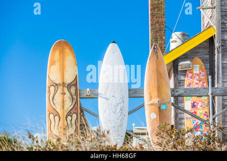 surf boards on display outside with a brilliant blue sky Stock Photo