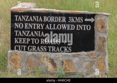 Road sign indicating the direction to the Tanzania border in Masai Mara National Reserve, Kenya Stock Photo