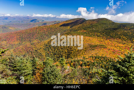 Cornell and Wittenburg Mountains shrouded in misty clouds, seen from a lookout on Slide Mountain during peak Autumn color in the Catskills Stock Photo