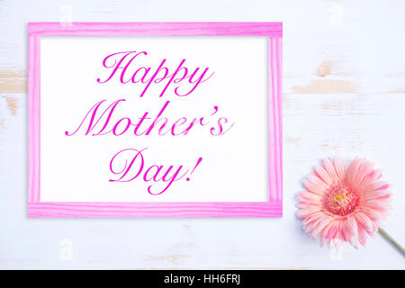 pink flower on white wooden table with frame and words Happy Mothers Day Stock Photo