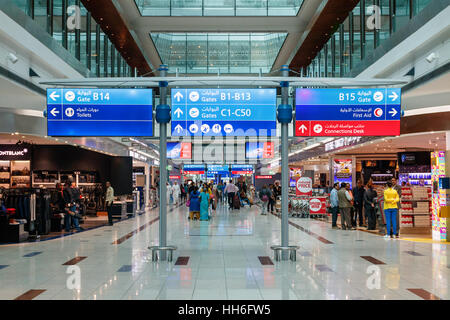 Shops and direction signs at one of the Dubai International Airport terminals. Stock Photo