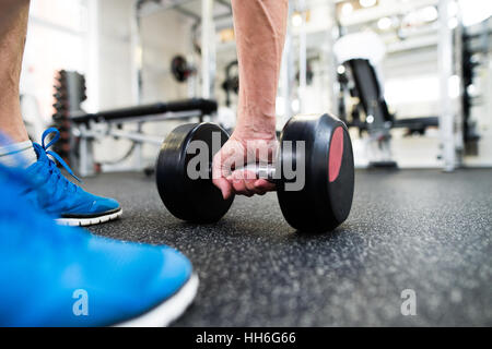 Unrecognizable senior man in gym working out with weights Stock Photo