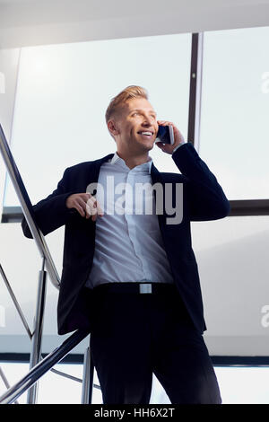 Businessman positive  blonde in a business suit talking on phone Stock Photo
