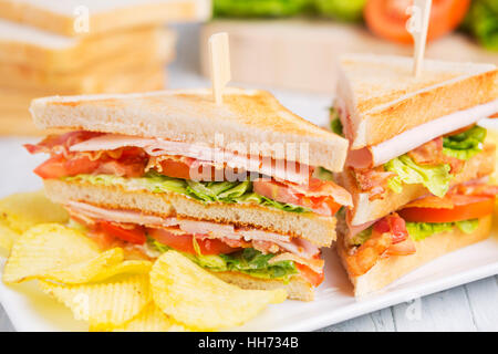 A club sandwich on a rustic table in bright light. Stock Photo