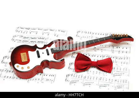 Musical notes, guitar and bow tie on white Stock Photo