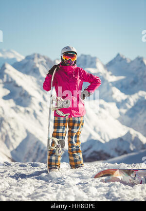 Female snowboarder in the alpine mountains Stock Photo