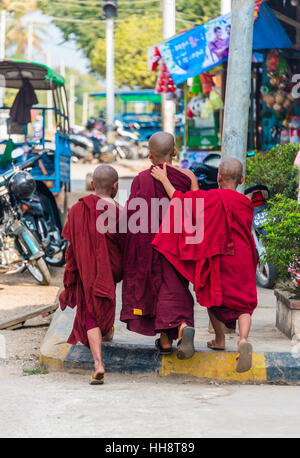 Young Buddhist monks walk on street, arm in arm, Kyaukme, Shan State, Myanmar Stock Photo