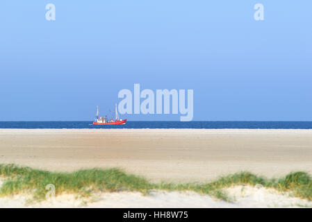 Red fishing boat in the North Sea, St. Peter-Ording Beach, Schleswig-Holstein Wadden Sea National Park, North Frisia Stock Photo
