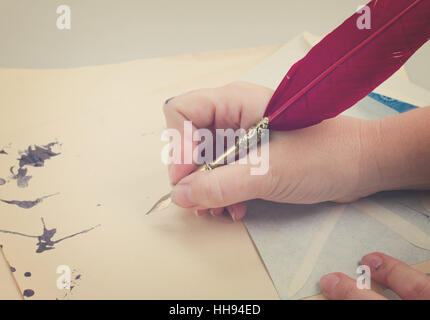 hand holding feather pen Stock Photo