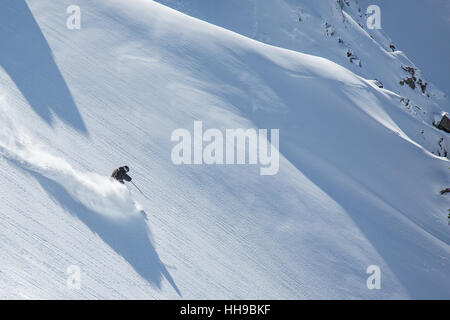 A backcountry skier slashing a turn down Mount Olympus on the south island of New Zealand Stock Photo