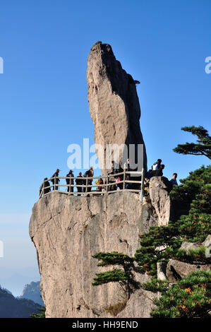 Tourists near a landmark rock on top of the Huangshan Yellow Mountain scenic area in Anhui province China. Stock Photo