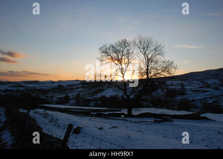 Sunset over snow covered landscape near Malham in Yorkshire Stock Photo