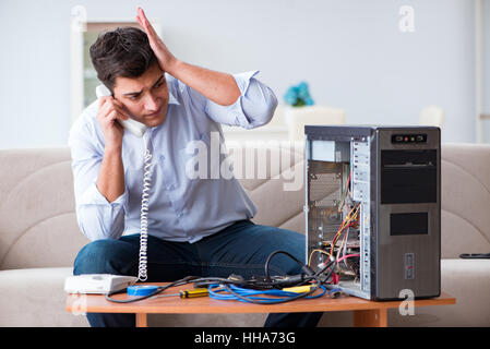 Angry customer trying to repair computer with phone support Stock Photo